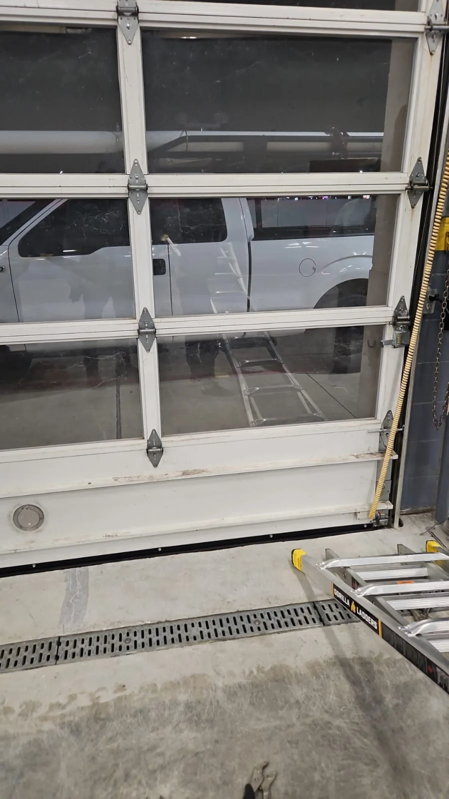 Commercial garage door repair for a large overhead glass door