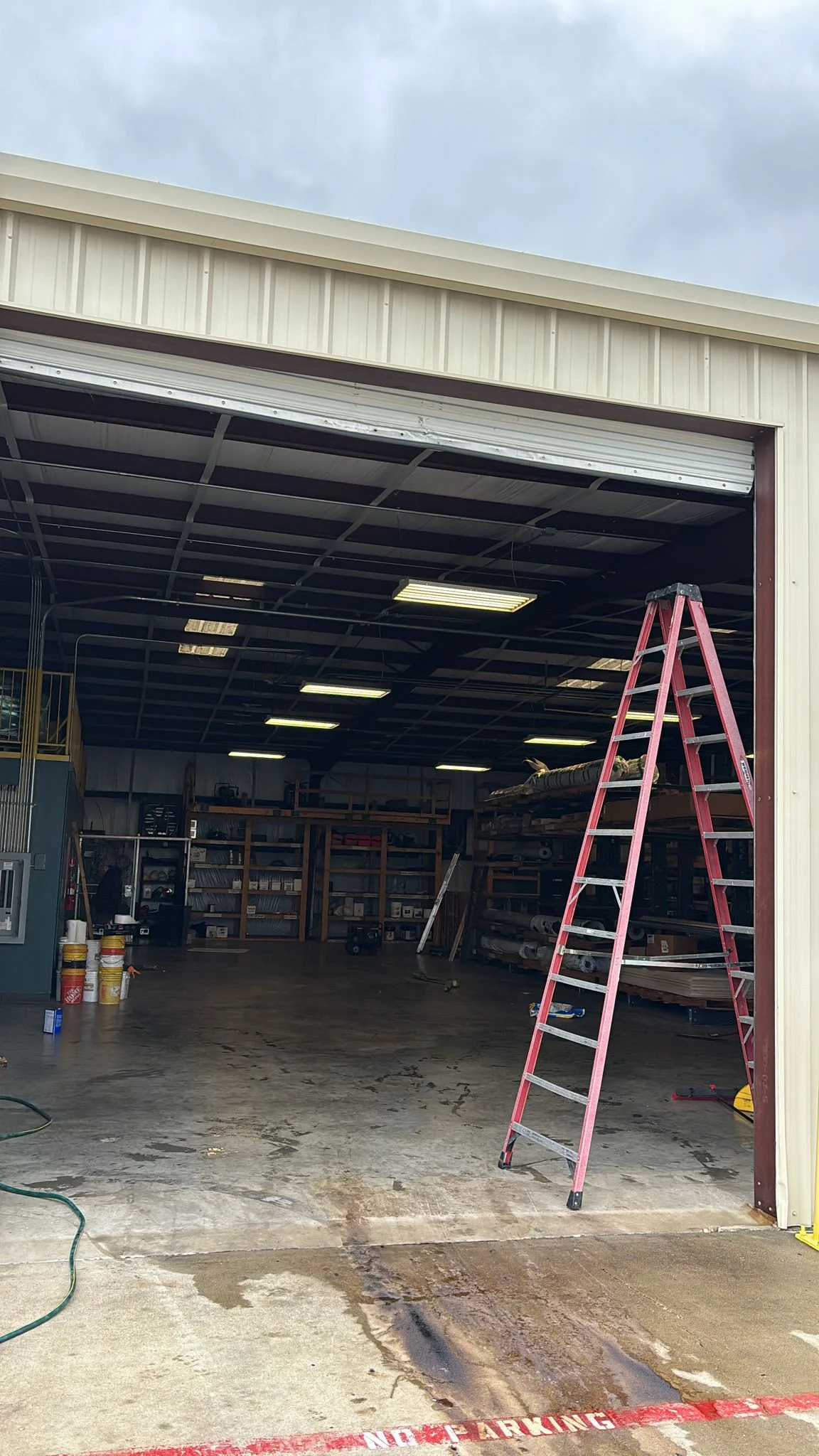 Professional commercial garage door repair on a high-lift sectional overhead door