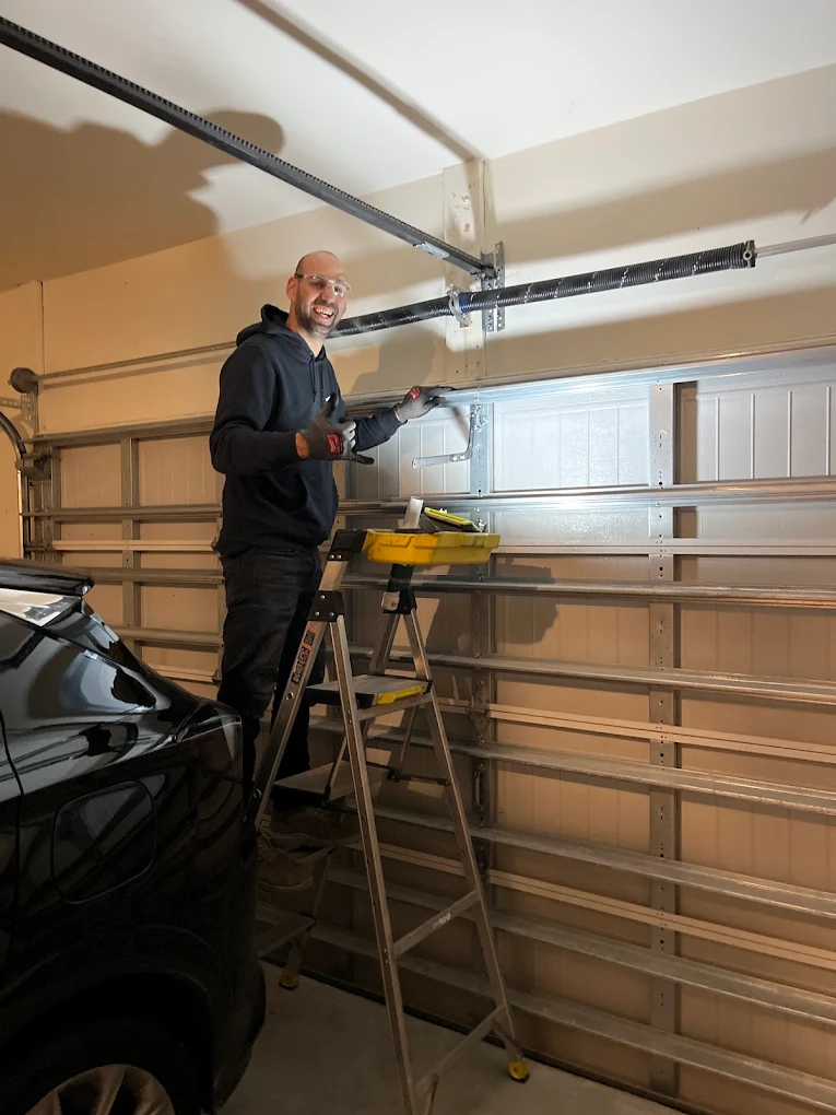 Non Stop Garage Door technician repairing a residential garage door torsion spring