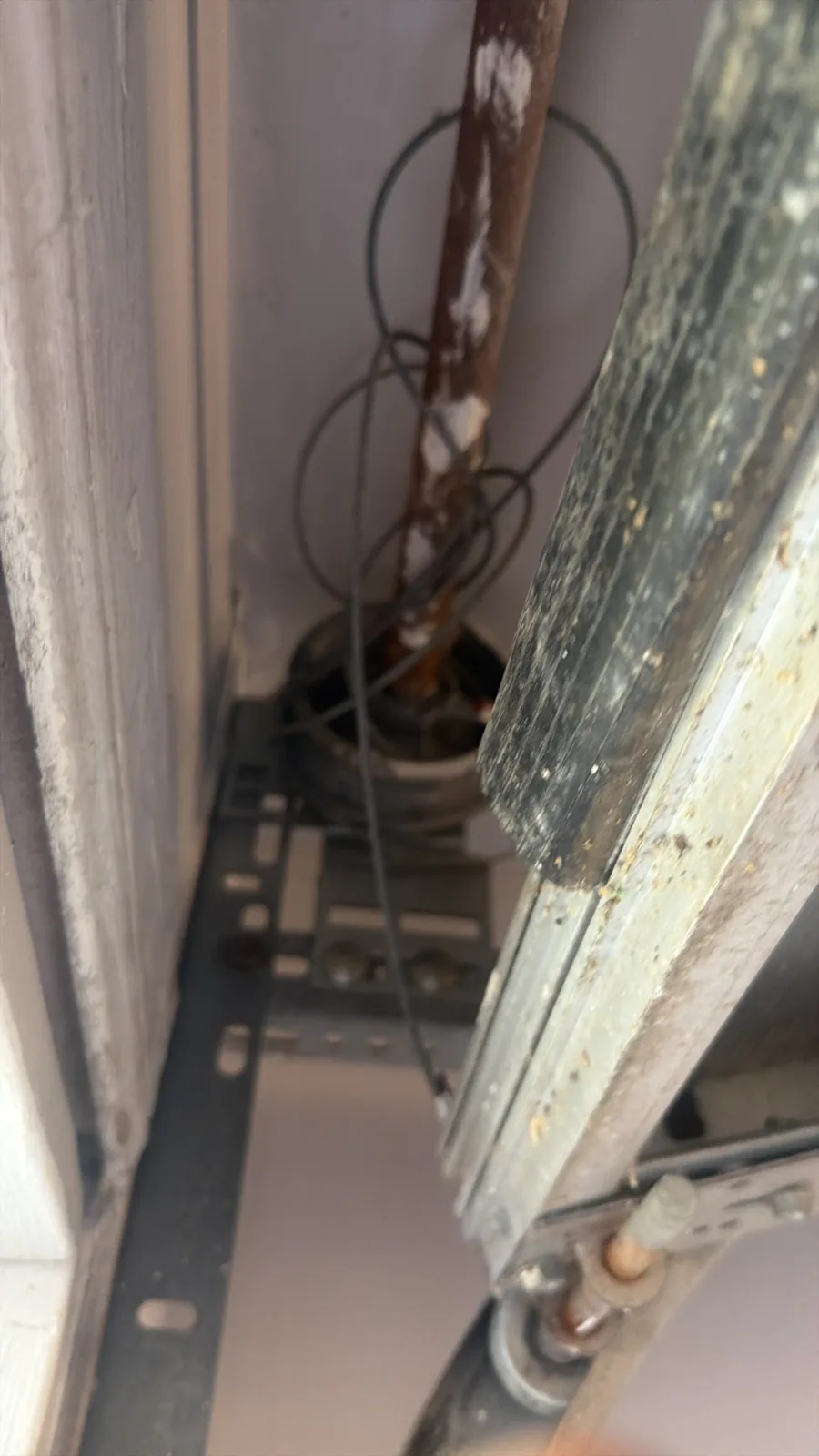 Loose garage door lift cable near roller and track during cable repair in Houston TX