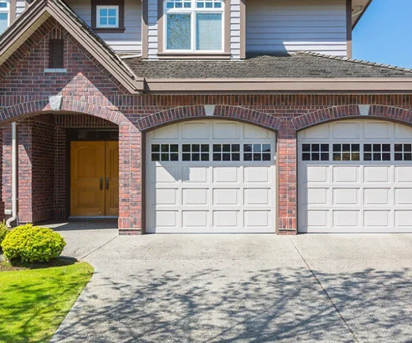 Beautifully installed garage doors with glass panels, complementing a modern home exterior in Houston, showcasing quality craftsmanship and curb appeal.